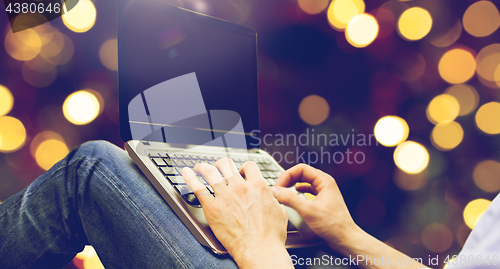 Image of close up of man typing on laptop keyboard