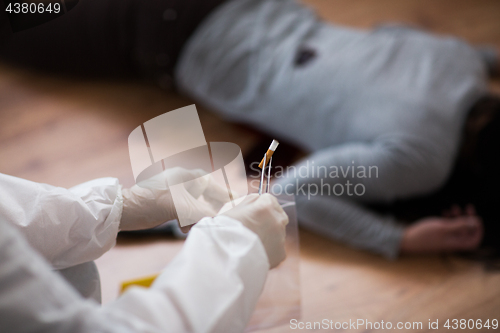 Image of criminalist collecting crime scene evidence