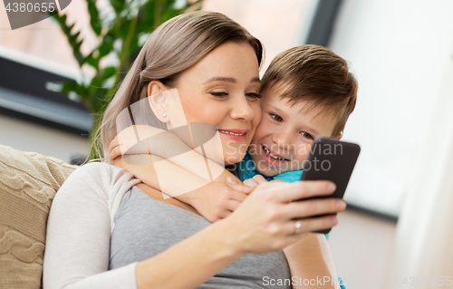 Image of happy family with smartphone at home