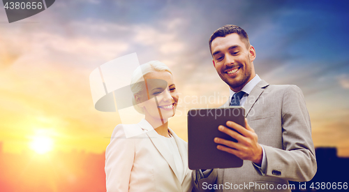 Image of smiling businessmen with tablet pc outdoors