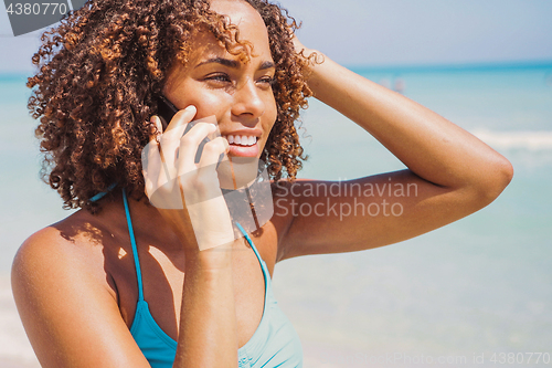 Image of Laughing woman talking phone at seaside