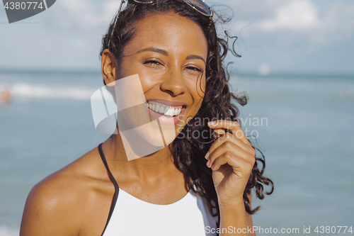 Image of Laughing black woman in swimsuit on beach