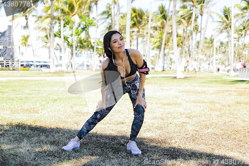 Image of Content ethnic woman stretching in park