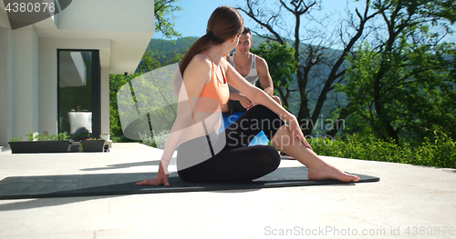 Image of Couple Doing Stretching Exercises Together in front of luxury vi