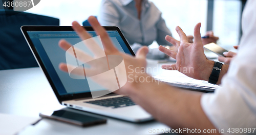 Image of group of business people having a meeting in bright office