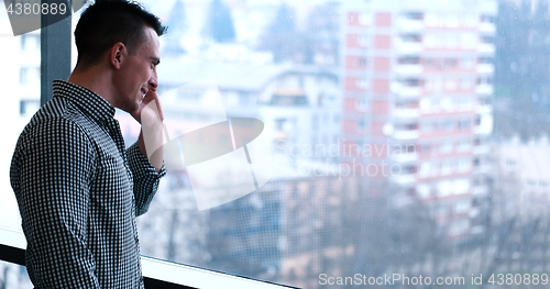 Image of Business Man Talking On Cell Phone, Looking Out Office Window