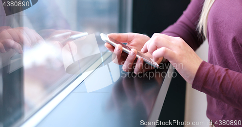 Image of Elegant Woman Using Mobile Phone by window in office building