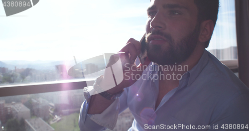 Image of Business Man Talking On Cell Phone At Home