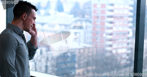 Image of Business Man Talking On Cell Phone, Looking Out Office Window