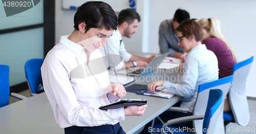 Image of Businesswoman using tablet with coworkers in backgorund having m