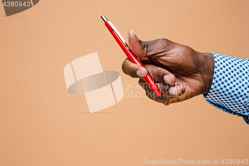 Image of Male hand holding pencil, isolated