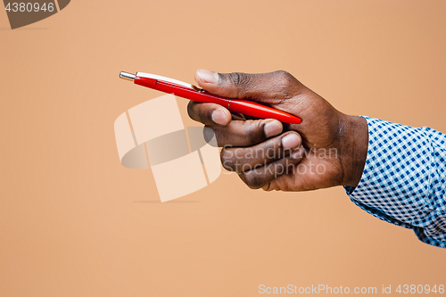 Image of Male hand holding pencil, isolated