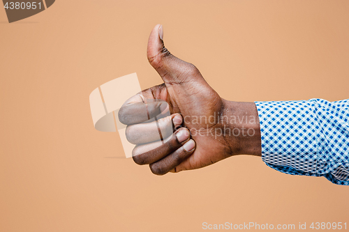 Image of Hand showing OK sign isolated on brown background.