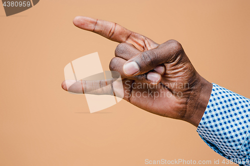 Image of Male, man, hipster, in shirt, hand raised showing a heavy metal rock sign