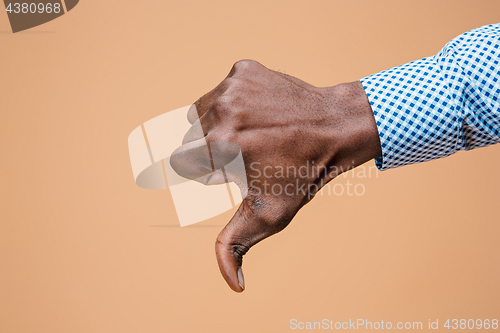 Image of Thumb down hand sign on brown, seal of disapproval