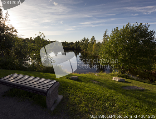 Image of A bench by the water in evening. Finland