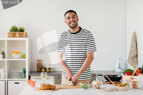 Image of man cooking food at home kitchen