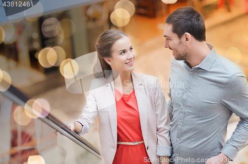 Image of happy young couple with shopping bags in mall