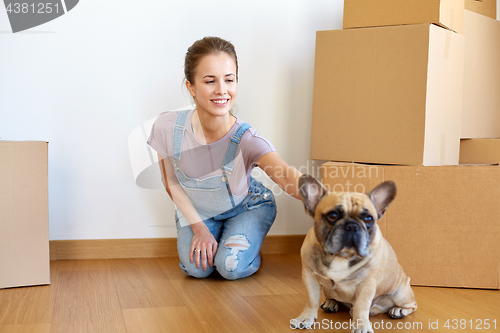 Image of happy woman with dog and boxes moving to new home