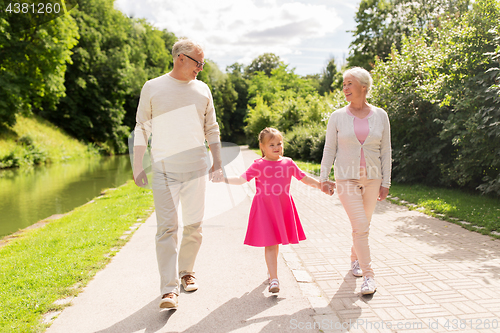 Image of senior grandparents and granddaughter at park