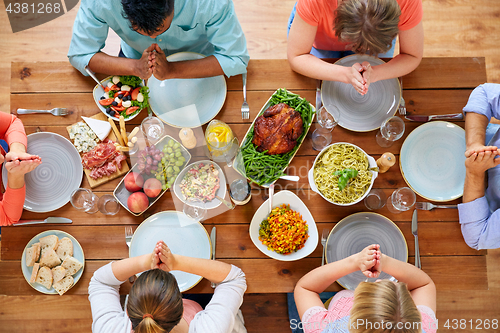 Image of group of people at table praying before meal