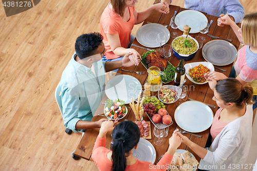 Image of group of people at table praying before meal