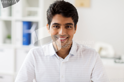Image of smiling indian businessman at office