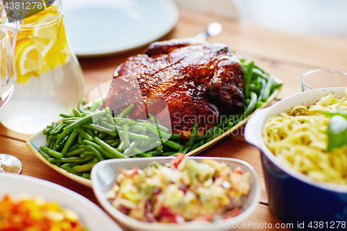 Image of roast chicken with garnish of green beans on table