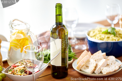 Image of bottle of wine and food on served wooden table