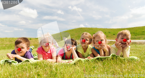 Image of happy kids lying on meadow at red nose day