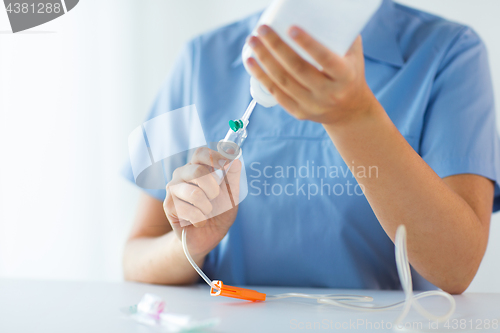 Image of close up of nurse preparing drop counter