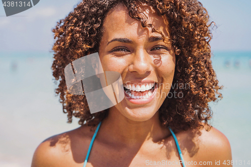 Image of Laughing ethnic woman at the ocean