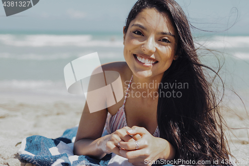 Image of Charming brunette in bikini lying on beach