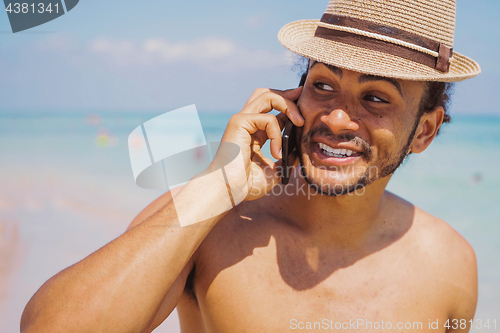 Image of Cheerful man standing with smartphone