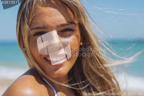 Image of Wonderful woman smiling in sunshine on beach