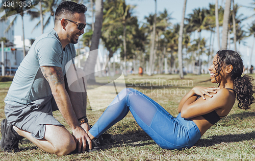 Image of Man supporting girl with abs training