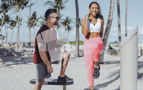 Image of Cheerful girl training with instructor on beach