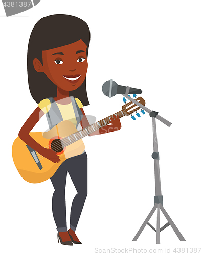 Image of Woman singing in microphone and playing guitar.