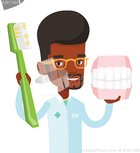 Image of Dentist with dental jaw model and toothbrush.