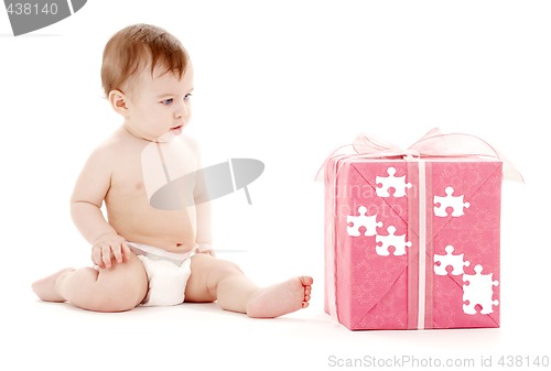 Image of baby boy in diaper with big puzzle gift box