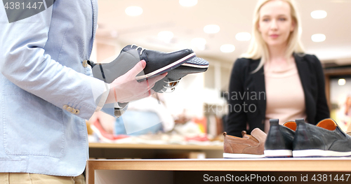Image of Man Chooses Shoes At Shoe Store