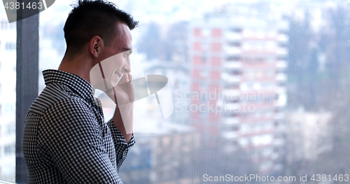 Image of Business Man Talking On Cell Phone, Looking Out Office Window