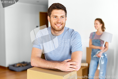 Image of happy couple with boxes moving to new home