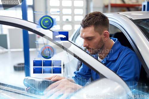 Image of mechanic man with diagnostic scanner at car shop