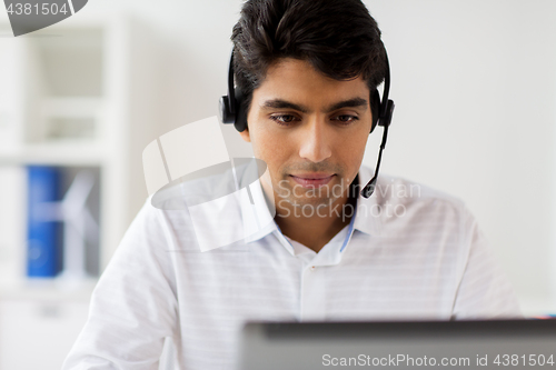 Image of businessman with headset and laptop at office