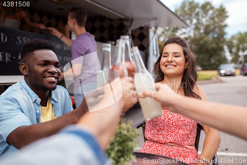 Image of friends clinking bottles with drinks at food truck