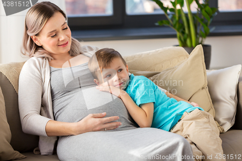 Image of happy pregnant mother and son hugging at home