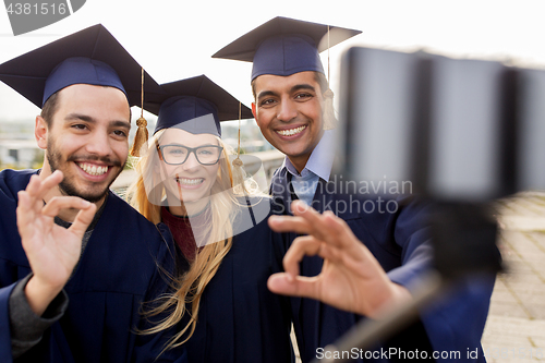 Image of students or graduates taking selfie by smartphone