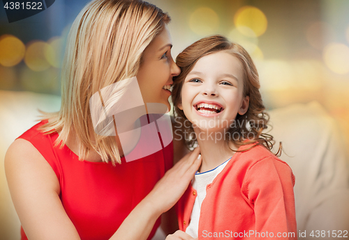 Image of happy mother and girl whispering into ear