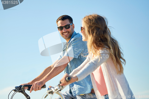 Image of happy young couple riding bicycles in summer